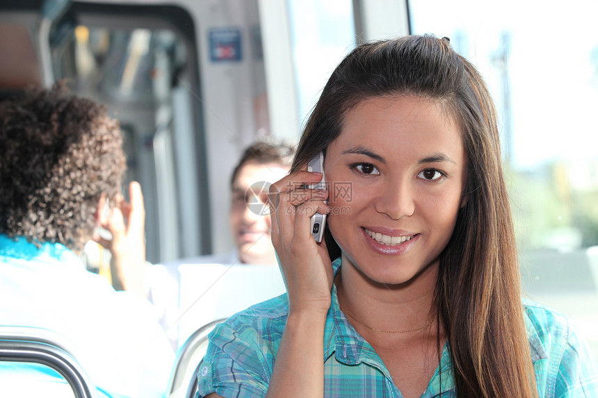 使用移动电话的年轻人女性学生棕色白色城市电话旅行呼唤女士头发图片
