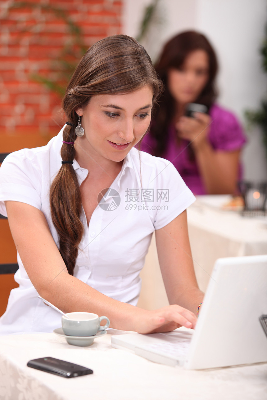 年轻女子在咖啡馆做电脑工作图片