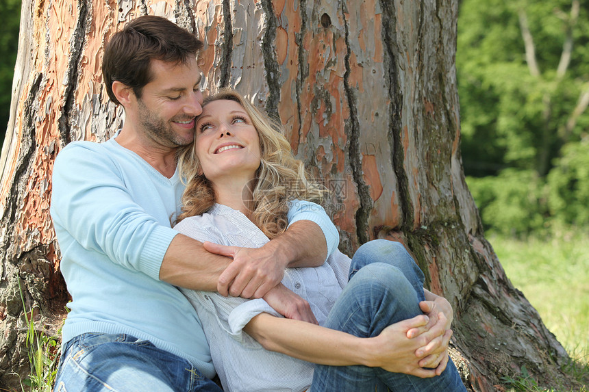 幸福的一对情侣坐在树边夫妻成人农村微笑拥抱图片