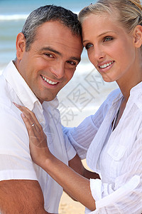 在海后面的一对夫妇 一个40岁的肌肉男和35岁的金发女郎背景图片