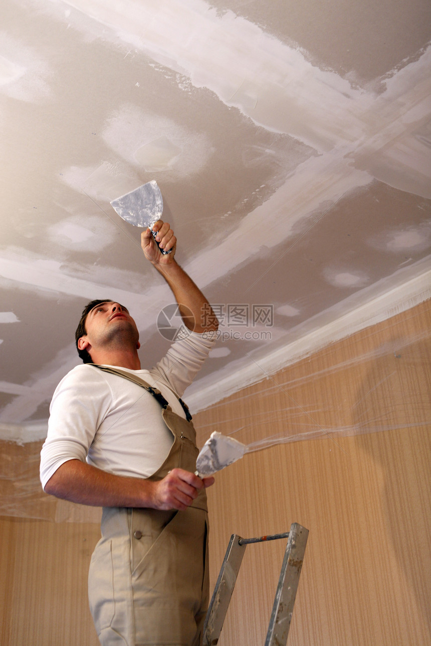 在天花板上工作的粉刷阁楼维修承包商工人泥水匠安全帽灰尘检修修理房子图片