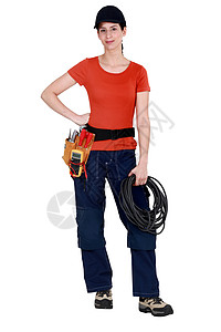 电工鞋手持电缆和戴工具带的女杂工背景