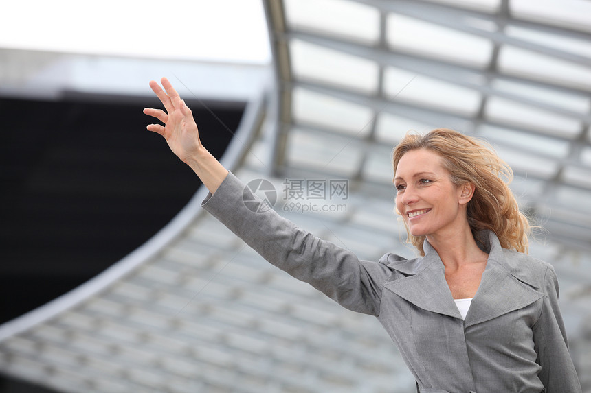 商业妇女挥手飞机场头发工作管理人员金发套装微笑旅行导演女士图片