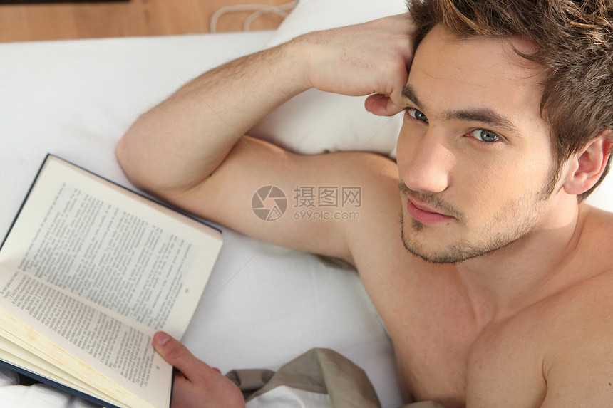 男人在床上阅读书胡子躯干专注小说文学沙发小憩乐趣长椅男性图片