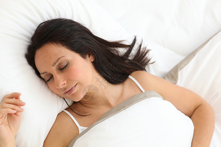 睡觉的年轻妇女休息卧室睡眠头发棕色背景图片