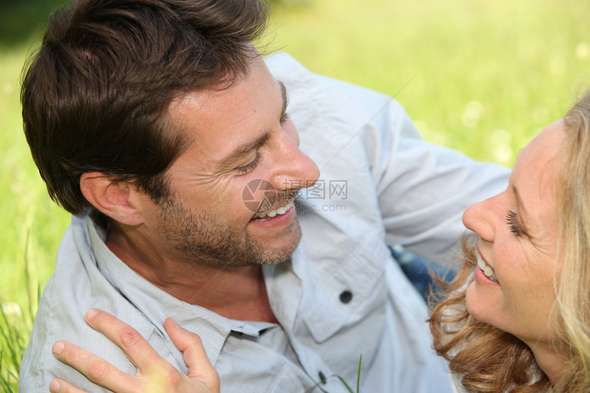 一对夫妇躺在草地上二人阳光衬衫纽带妻子伙伴闲暇午餐野餐情感图片