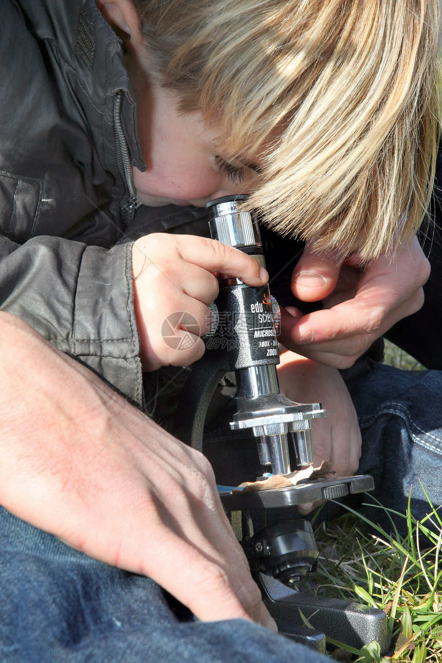 使用显微镜户外显微镜的好奇小男孩图片
