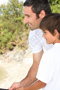 父亲和儿子在钓鱼青春期运动海岸晴天教学中年人照片学习支撑男生背景图片
