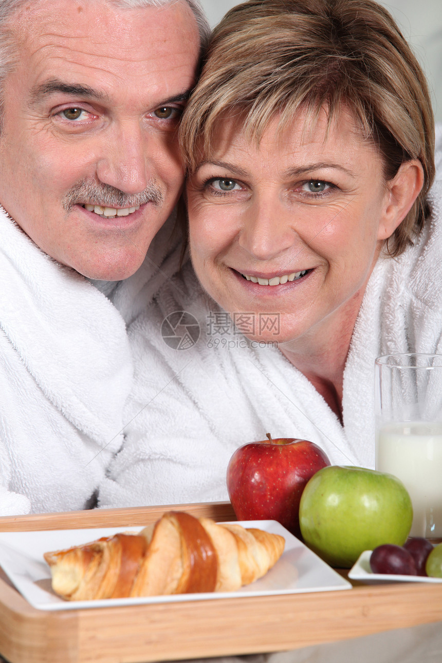 高龄夫妇吃早餐妻子厨房丈夫胡子男人桌子水果牛奶面包玻璃图片