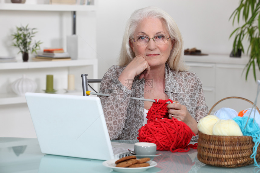 老年妇女用膝上型电脑编织图片