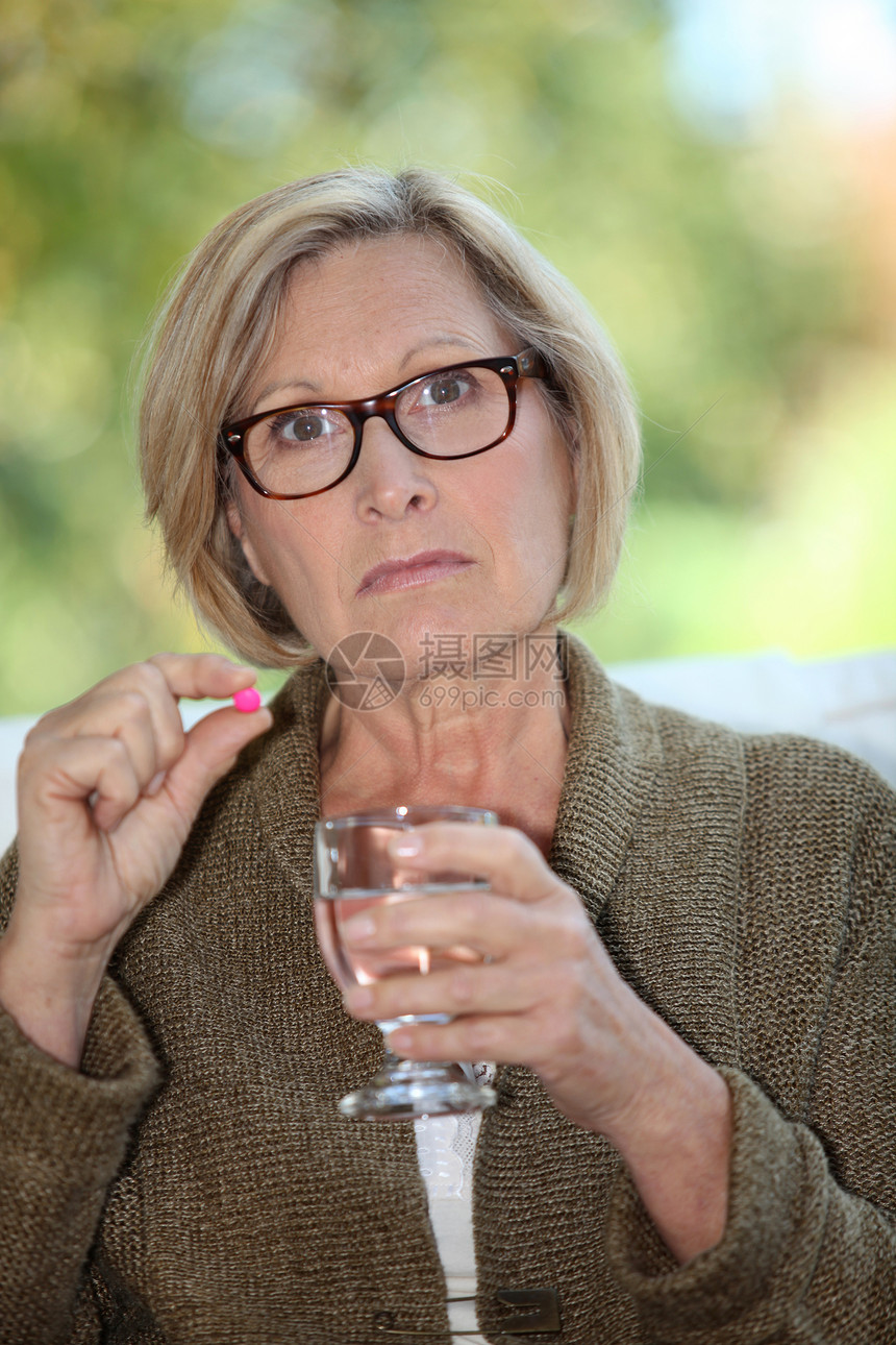 一个吃药的老妇人疾病眼镜展示生活卫生女士药片退休手指保健图片