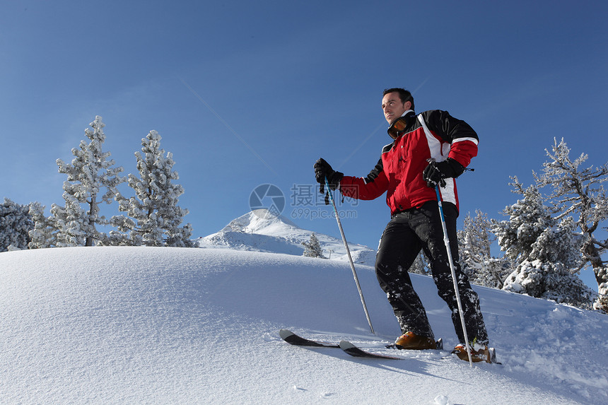 人在阳光明媚的一天滑雪两极山脉男人蓝色滑雪板跑步丘陵速度极限下坡图片