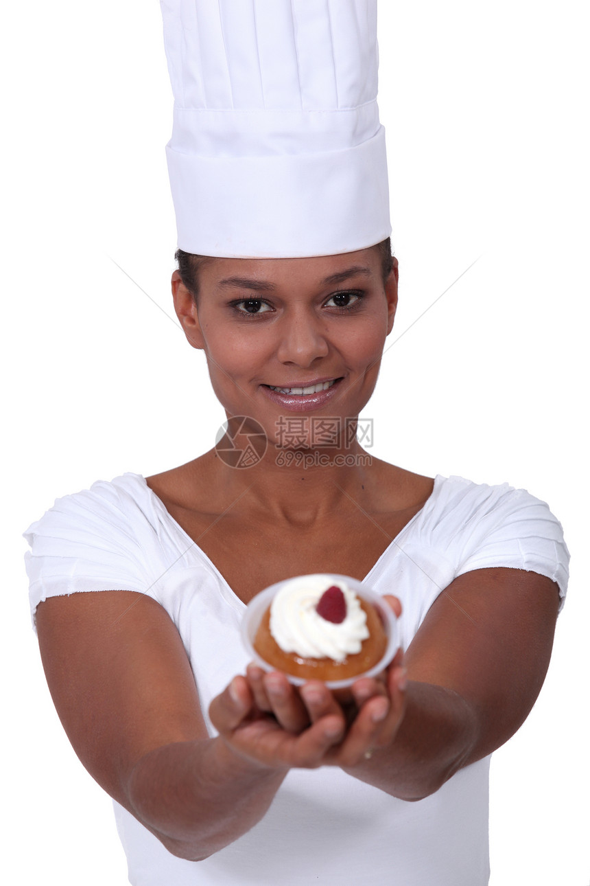拥有糕饼的年轻女性面包师图片