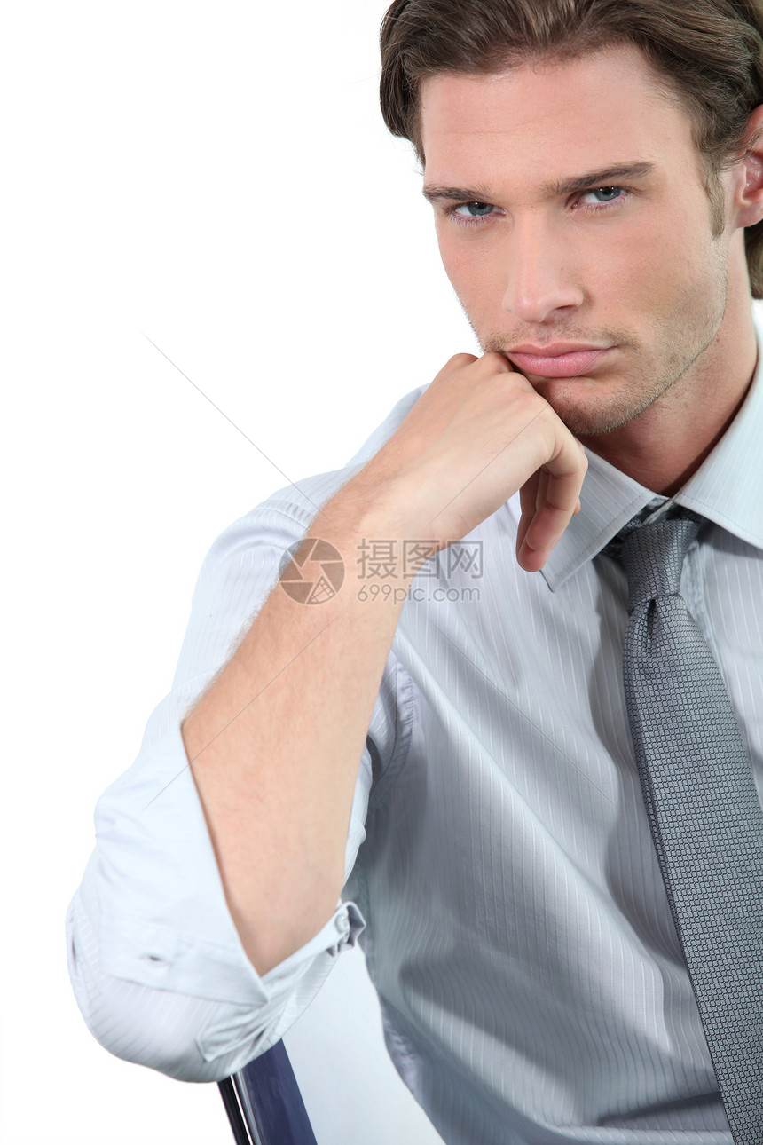 年轻商务人士靠在椅子上领带衬衫白色倾斜蓝色实习生眼睛套装男性棕色图片