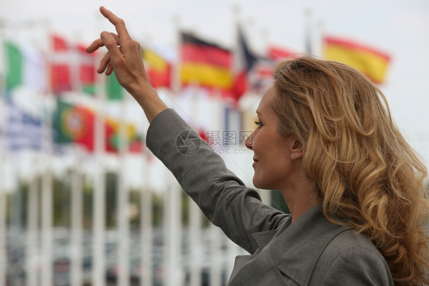 妇女在国际旗帜前向计程车欢呼图片