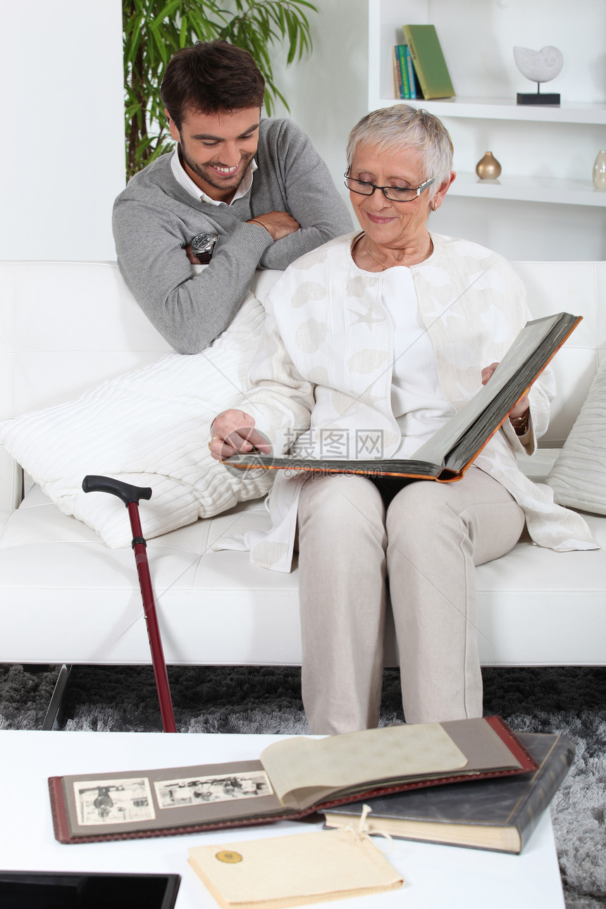 与儿子一起看相片的老年人女士女性棕色关爱眼镜教育头发白色灰色帮助图片