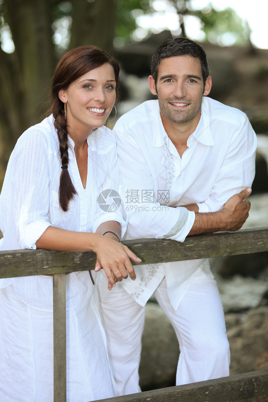 白白色的一对夫妇靠在乡村围栏上图片