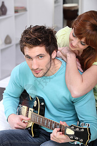 带吉他回家的年轻夫妇夫妻情人关爱女士朋友闲暇韵律吉他手妻子男人背景图片