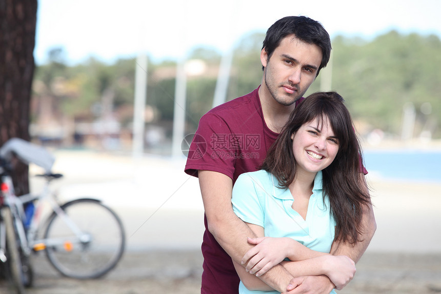 在湖边骑自行车的年轻夫妇图片