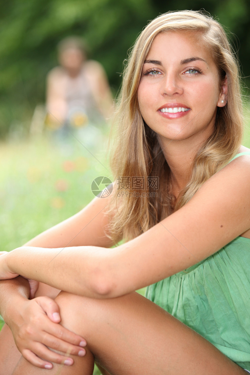 夏天坐在草原上的年轻女人图片