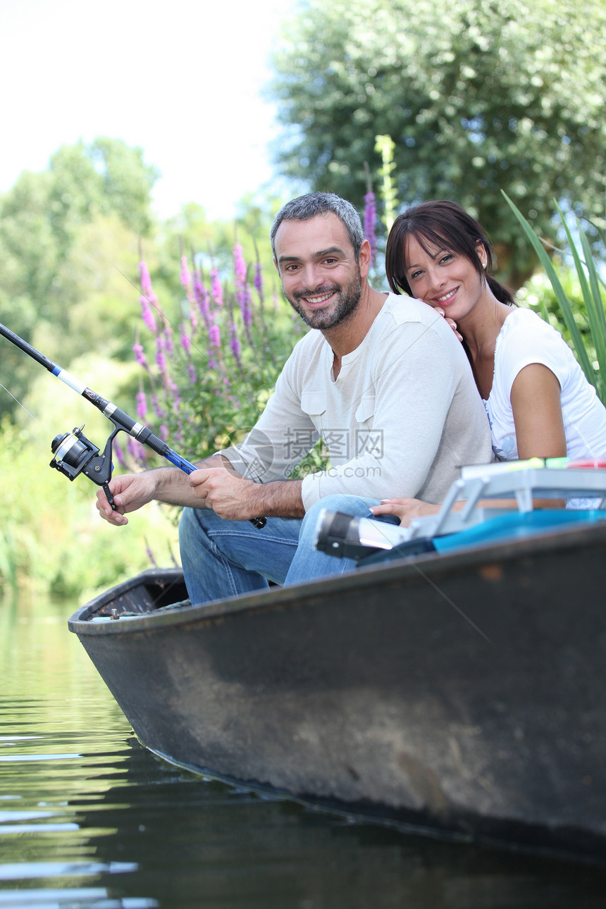 夫妻在湖边的船上钓鱼图片