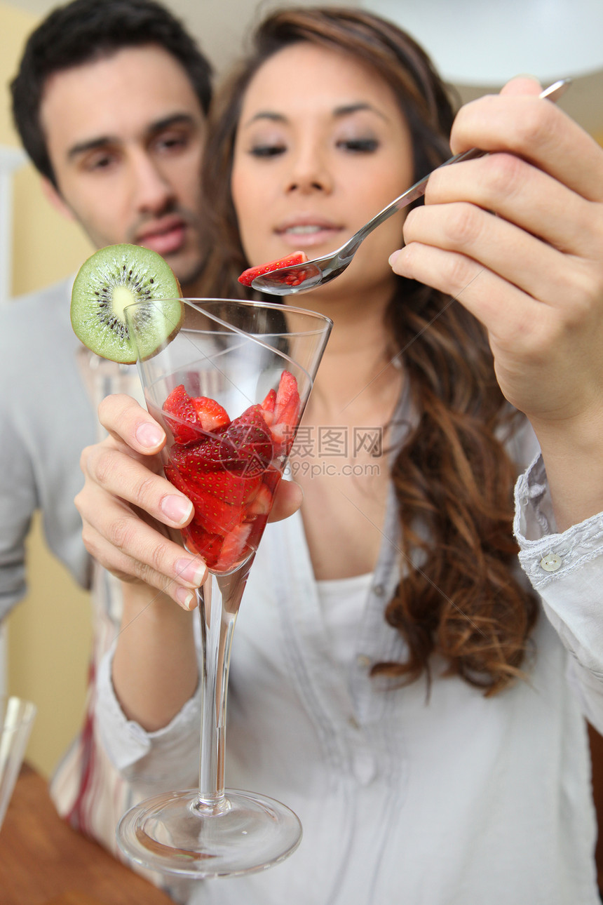 一对夫妇从一杯中吃草莓图片