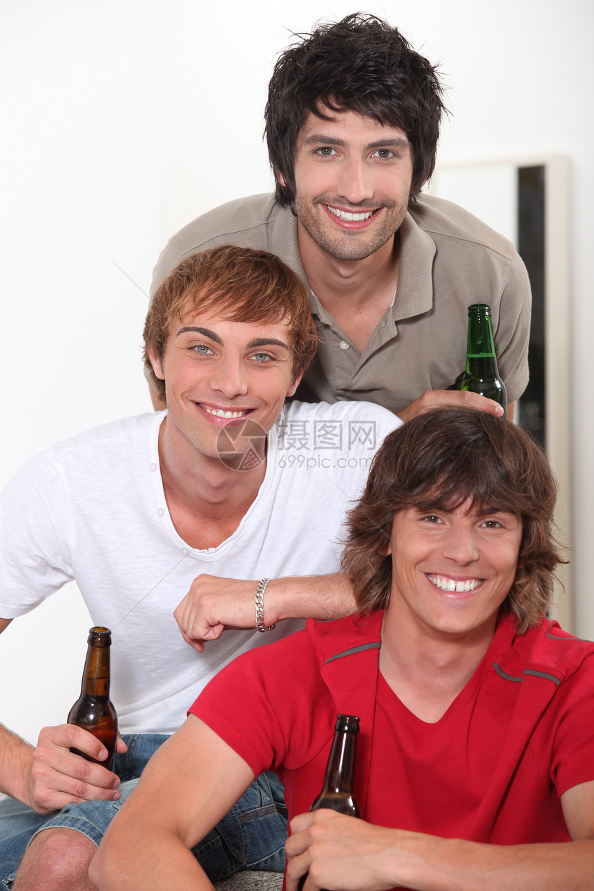 三个小伙子拿着一瓶啤酒图片