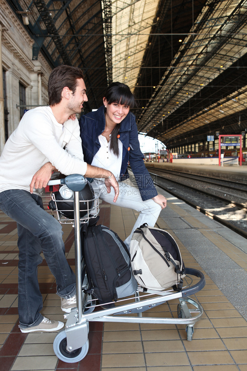 一对在等火车背包男人运输旅行背囊平台旅行者女士游客乐趣图片