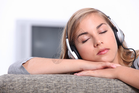 女孩听音乐头发沙发女士眼睛女性白色耳机音乐棕色睡眠背景图片