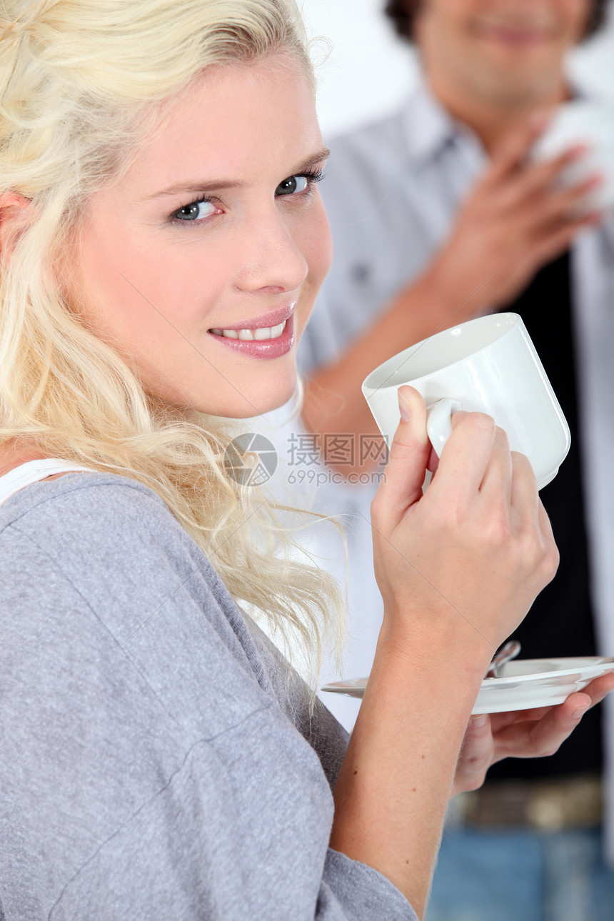 喝热饮的年轻女子成人头发飞碟女性快乐金发女郎杯子巧克力咖啡图片
