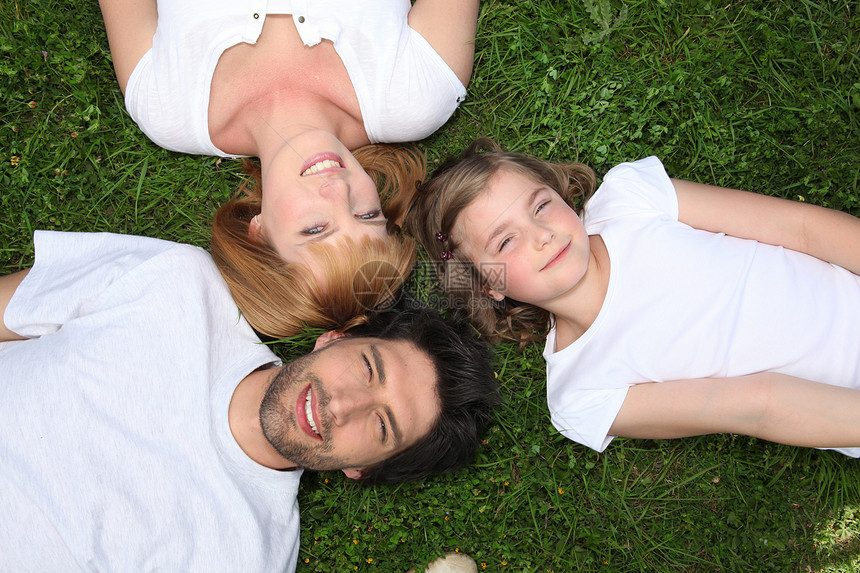 家庭穿着白衣服躺在草地上图片
