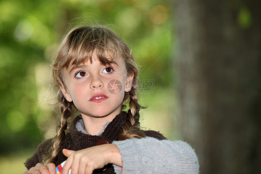 公园里的小女孩女孩童年牙齿头发乐趣辫子生活快乐开襟衫草地图片