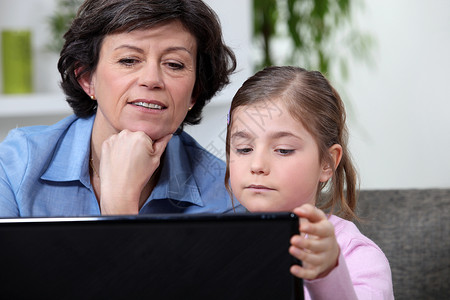年轻女孩与祖母在互联网上互连网高清图片
