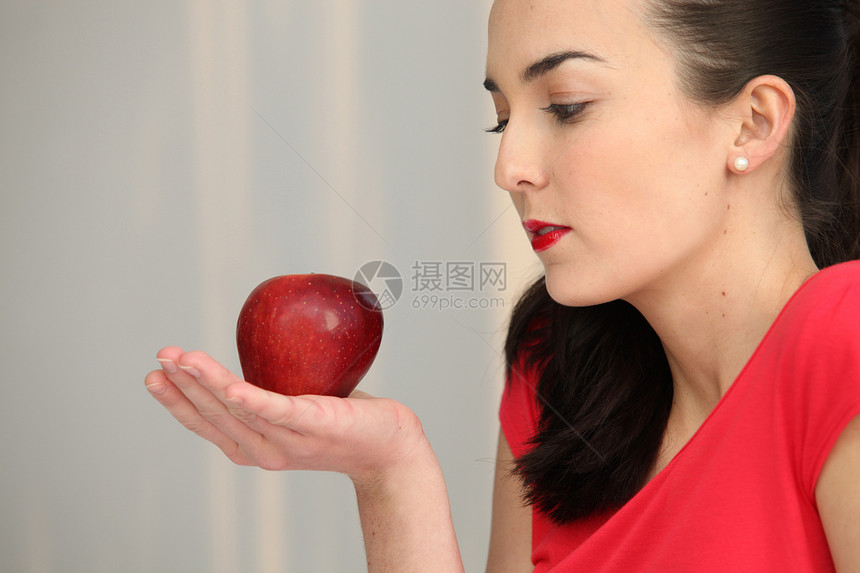 手掌中握着红苹果的女子图片