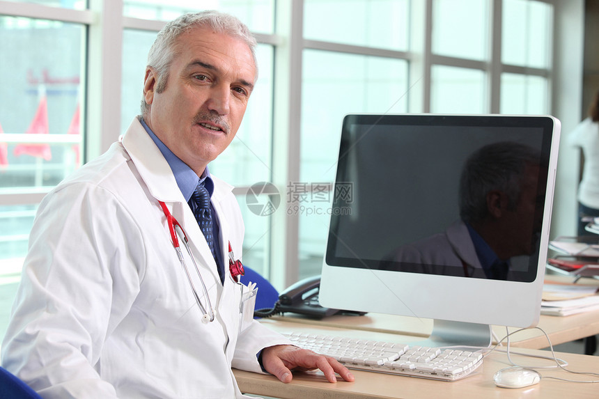 医生在书桌上工人白色专家技术桌子键盘工作男性办公室医院图片