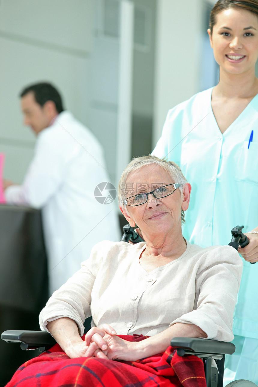 与年轻护士一起坐轮椅的年长妇女图片