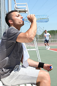 网网球法庭边线上的人类饮用水高清图片