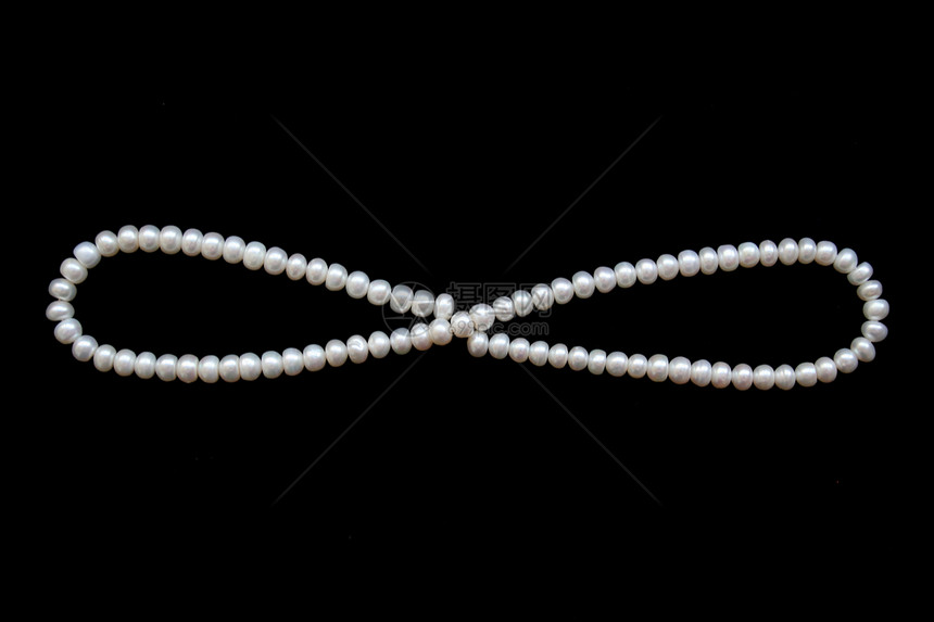 黑色丝绸上的白珍珠作为背景展示首饰光泽度反射象牙珠子项链奢华婚礼细绳图片