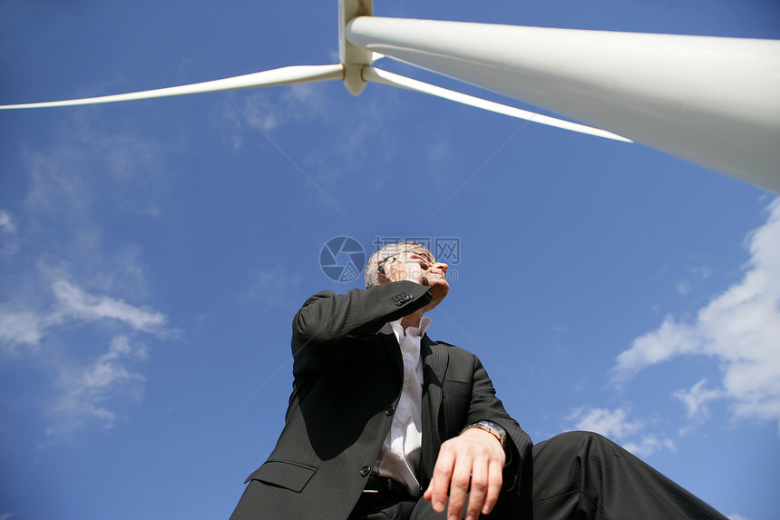 靠近风力涡轮机的男子图片