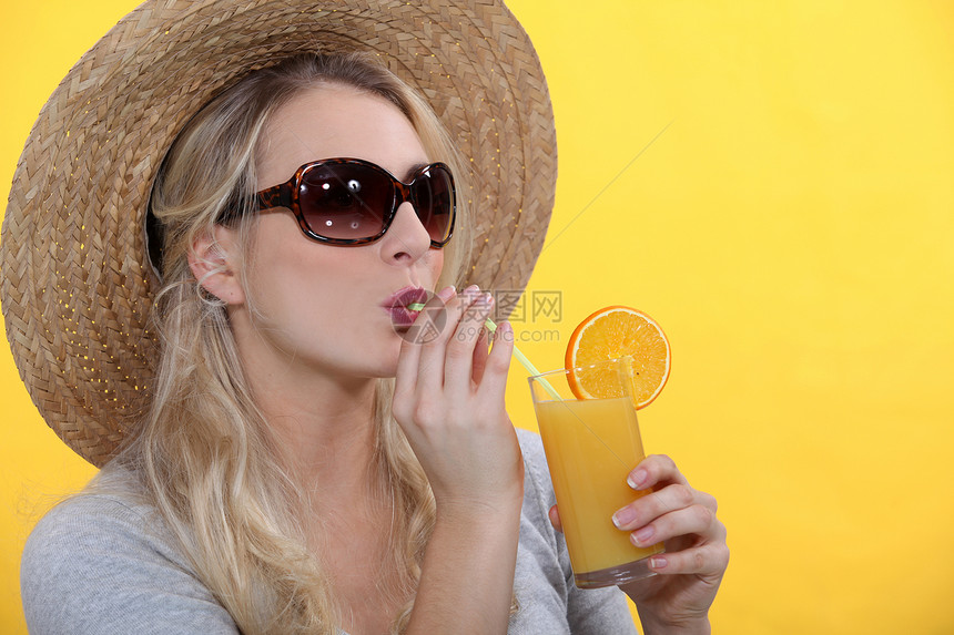 喝橙汁的妇女视图女士文件太阳镜饮食头发果汁金发玻璃太阳图片