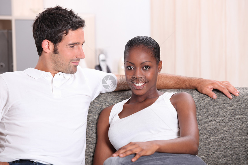 年轻夫妇在家放松肩膀家庭妻子丈夫记录娱乐白色手臂家具男人图片