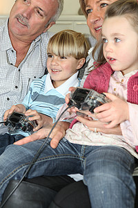 玩电子游戏的家庭女士妈妈娱乐童年游戏竞争爸爸男人乐趣父亲背景图片