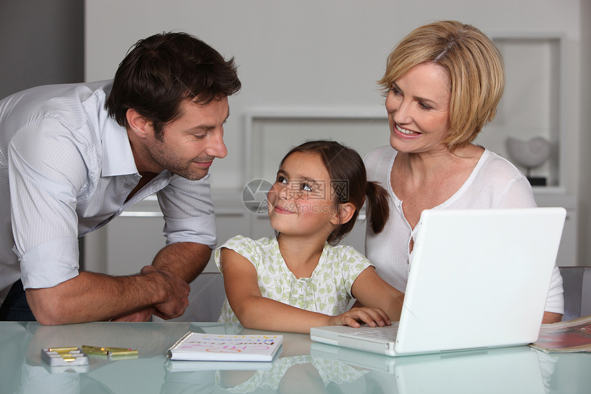 膝上型计算机的家长和年轻女儿图片