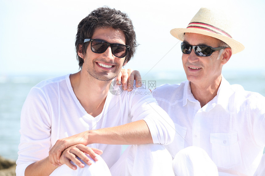 父亲和儿子在海滩上乐趣男生孙子家庭祖父男人海洋爸爸假期父母图片