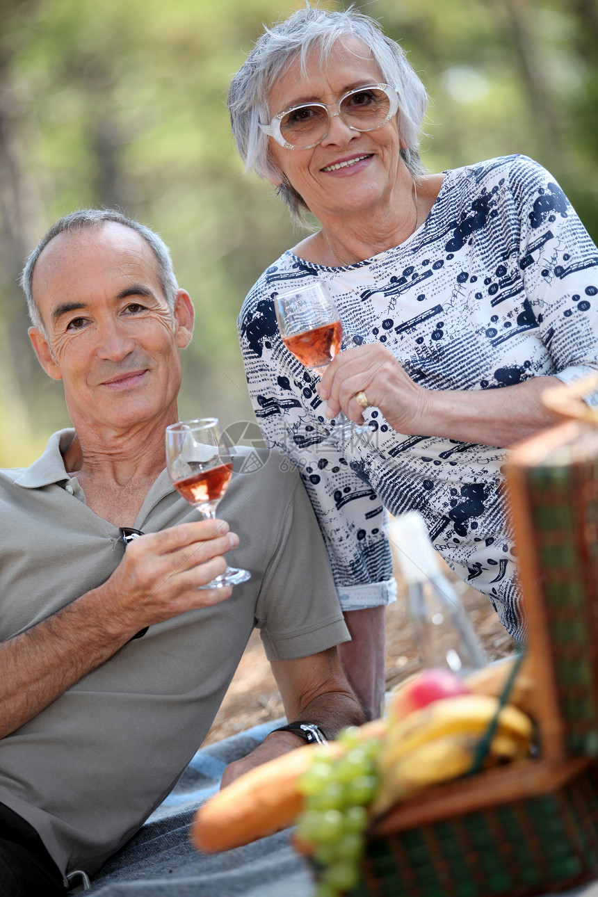 年长夫妇在野餐中饮玫瑰酒图片