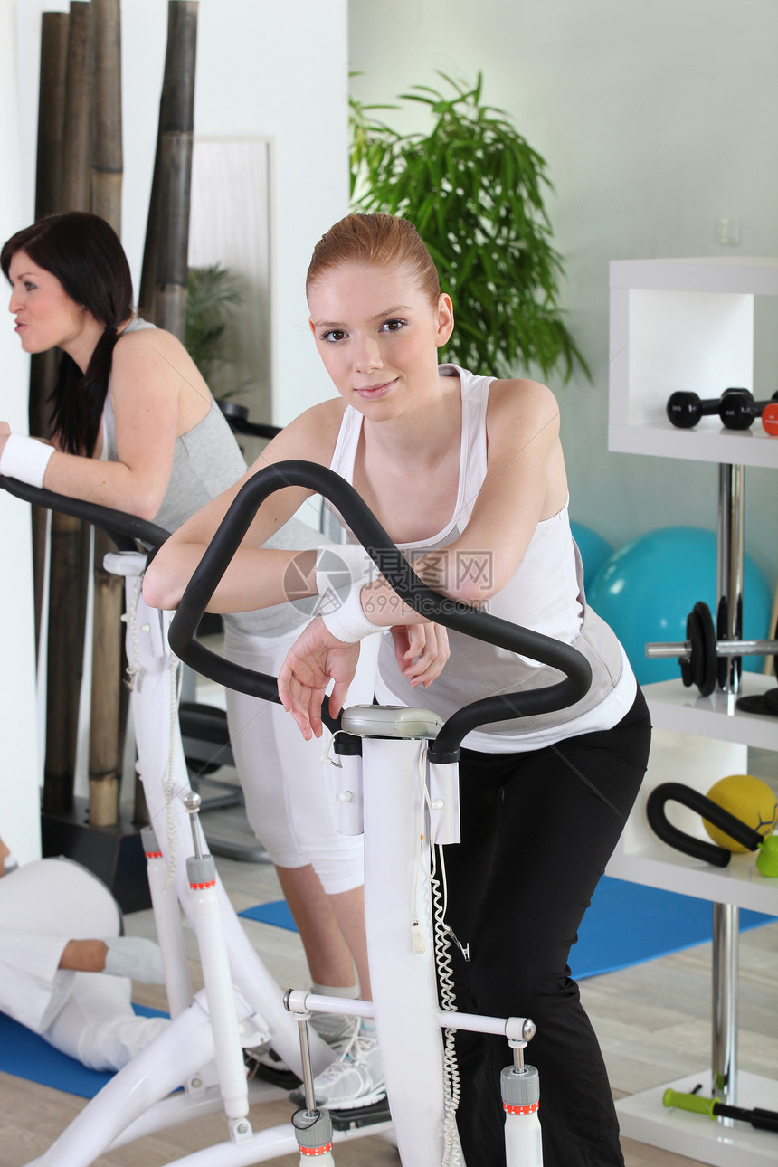 年轻妇女在健身房工作图片