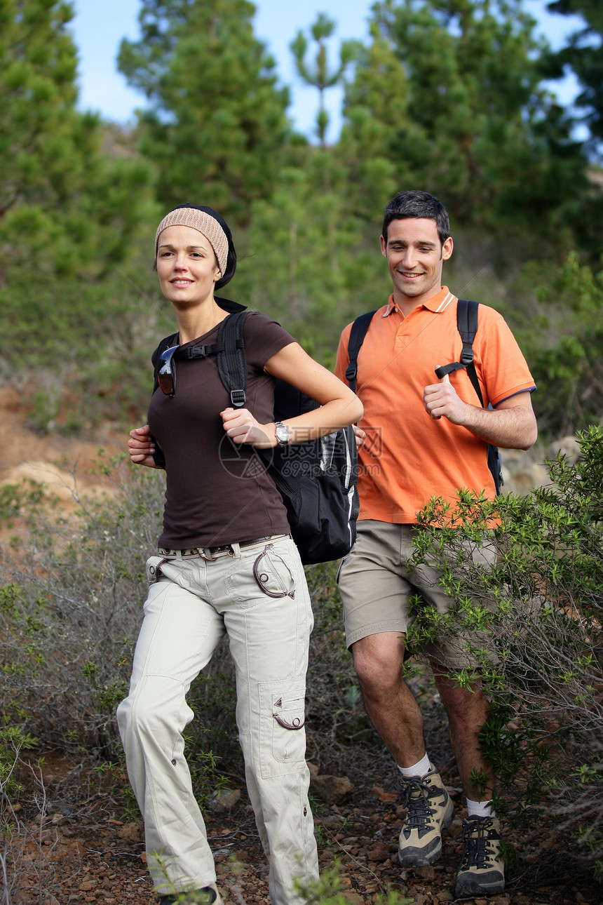 年轻夫妇在树林里徒步旅行图片
