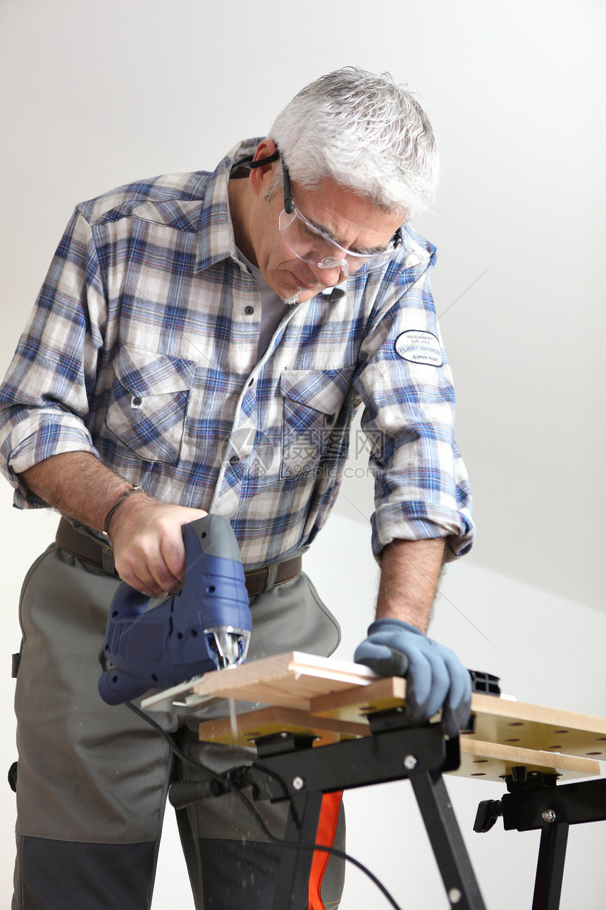 商务人士使用拼锯工作作坊工具力量工人工作台商务头发衬衫风镜图片