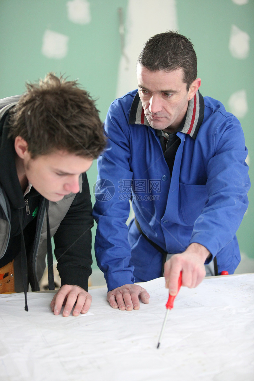 建筑工和他的学徒商业联盟石膏板安全铅笔工程师蓝色工程零售商图纸图片