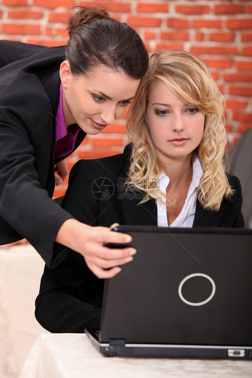在笔记本电脑上工作的年轻妇女桌子商业微笑头发人士商务快乐女性职业金发女郎图片